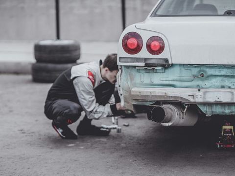 A mechanic working under the hood of a customer's car